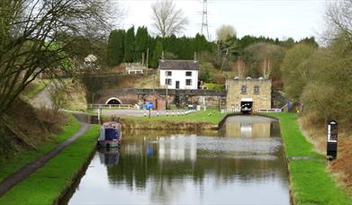 A canal on a cloudy day, with a tunnel in the distance