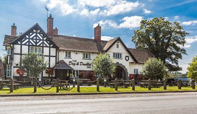 Image shows the front of The Dog & Doublet Inn, taken on a sunny day
