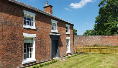 Photo shows the front of the Gardners Cottage on a sunny day