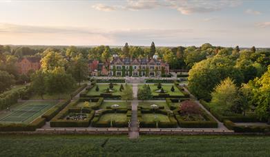 A drone shot of Hoar Cross Hall at sunrise, showing the perfectly manicured grounds and the beautiful surroundings