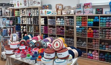image of shop interior, shelves with different colours of yarn