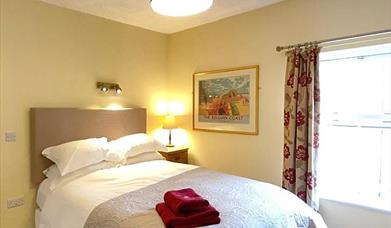 One of the bedrooms at The Victoria in Newcastle-under-Lyme, Staffordshire. Image shows the bed and furnishings.