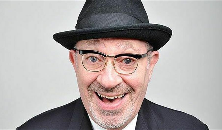 Image is a man looking at the camera, laughing
