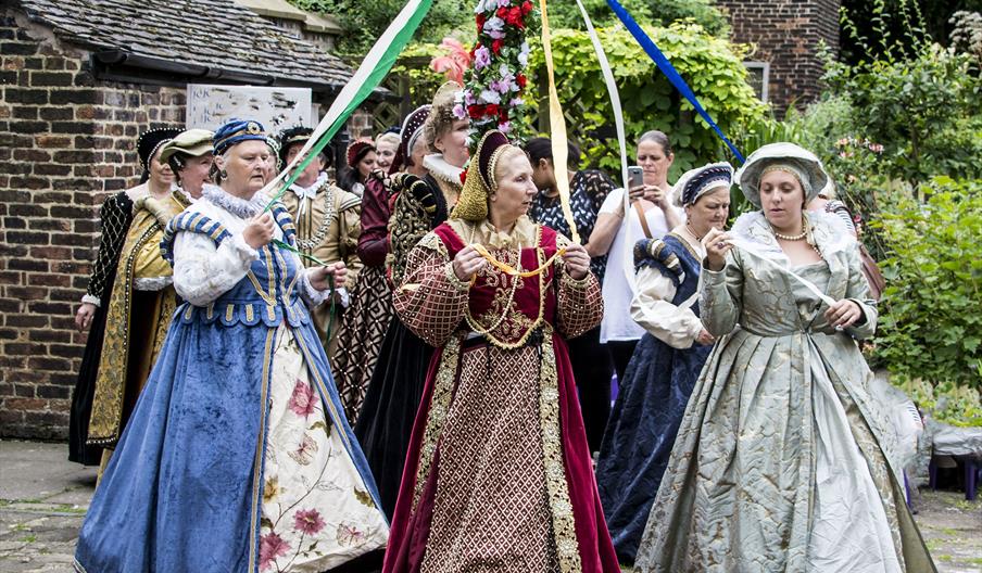 Costumed characters dance around the Maypole at Ford Green Hall, Staffordshire