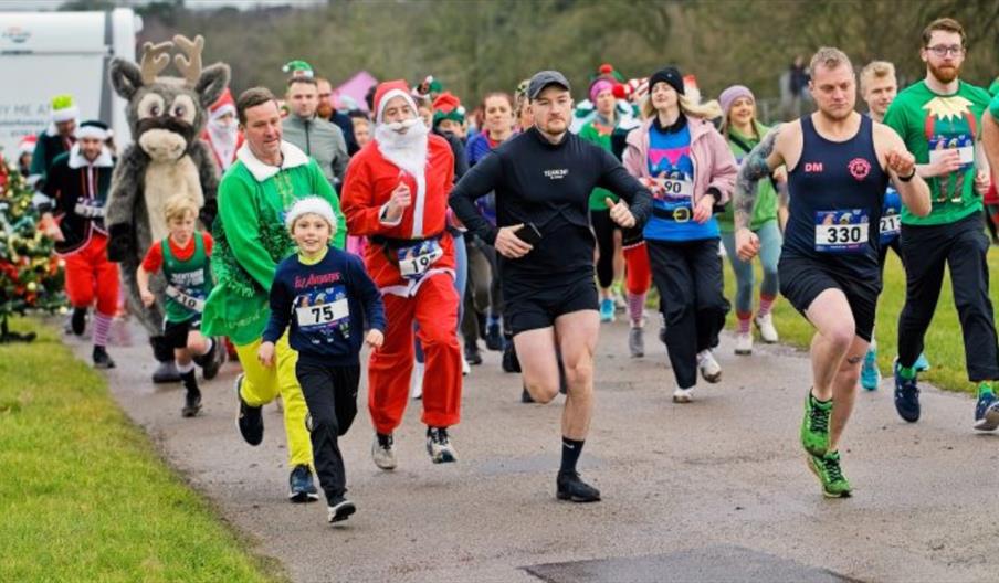 A group of runners, some in festive fancy dress, taking part in a fun run
