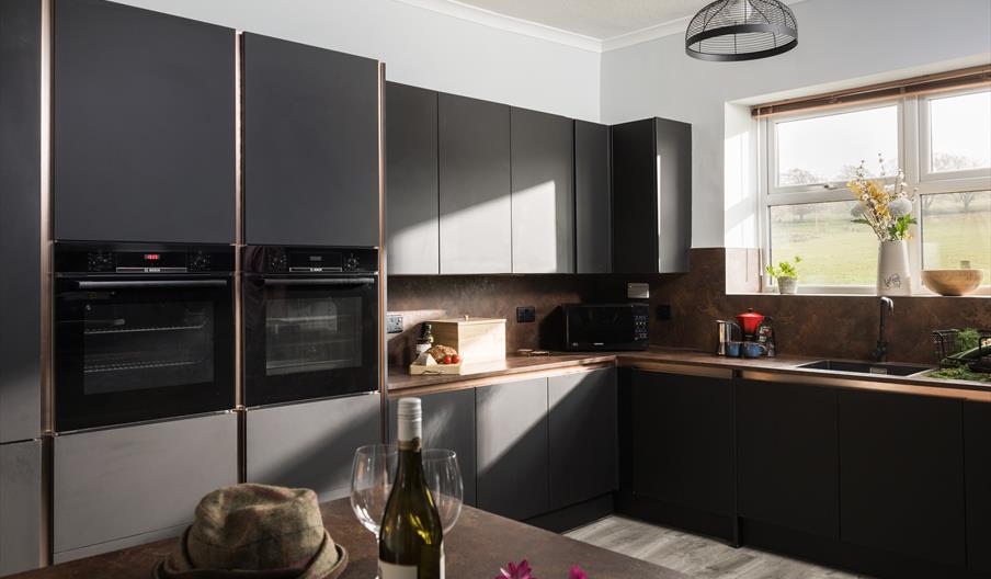 A modern, spacious kitchen with rays of sunshine coming in through the window