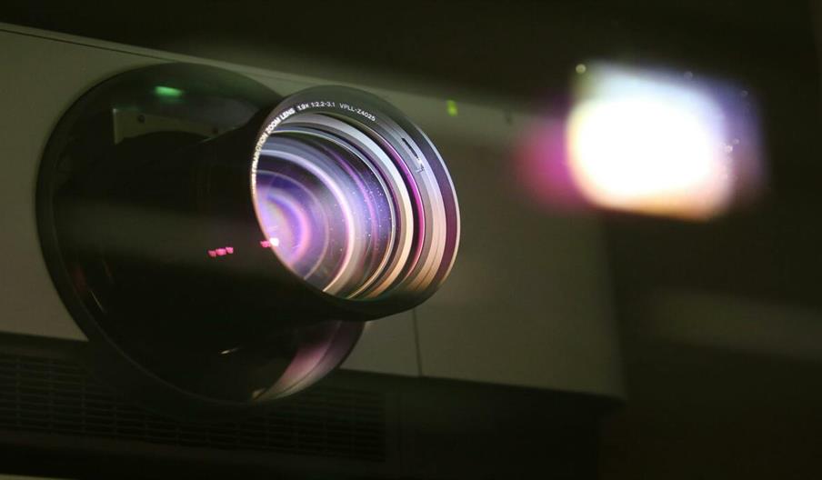 Close-up view of a projector lens emitting light
