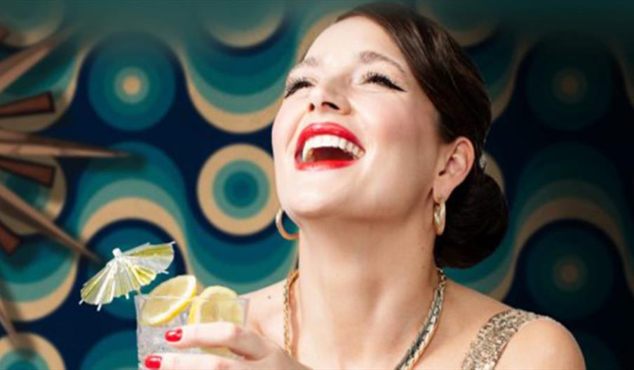 Photograph of woman laughing holding cocktail