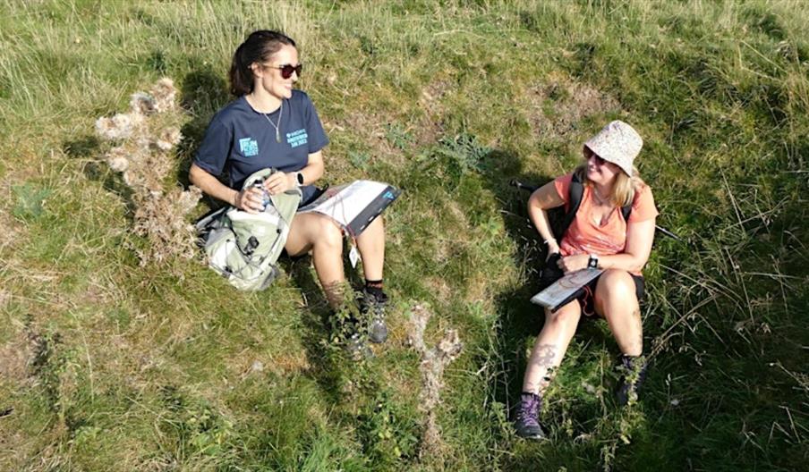 two female walkers resting on the grass