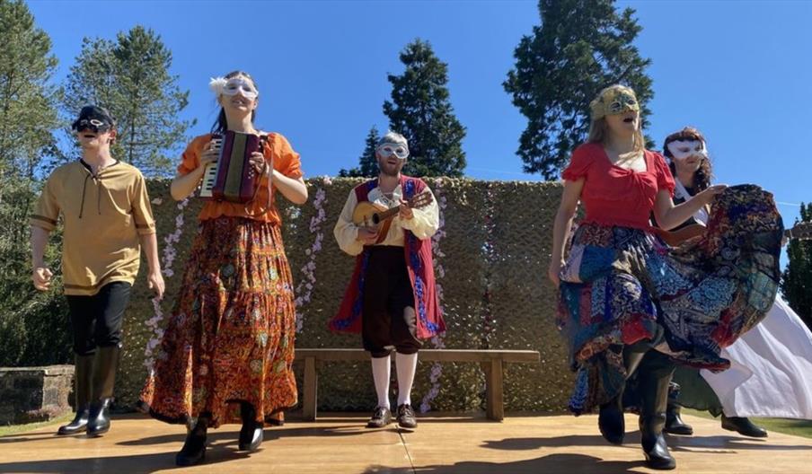 image of an outdoor performance with 5 actors on stage