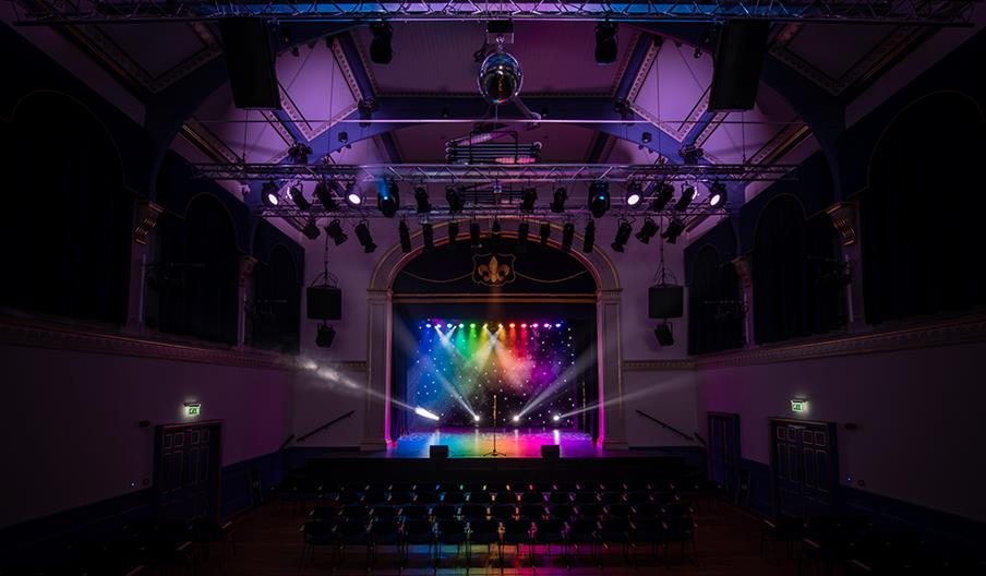 A light show underway inside a theatre auditorium, before guests arrive