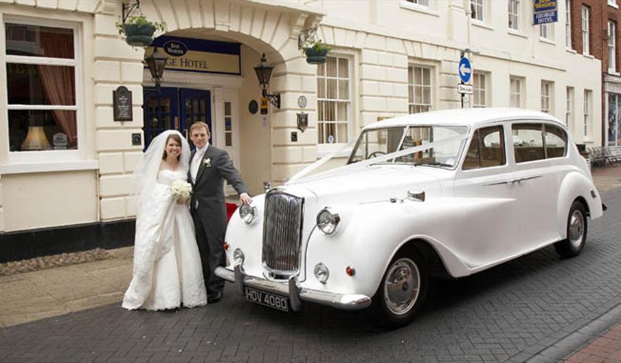 Classic Car with Bride and Groom outside the George Hotel.