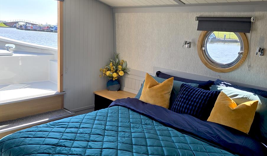 A bedroom on board the boat, with the marina in the background