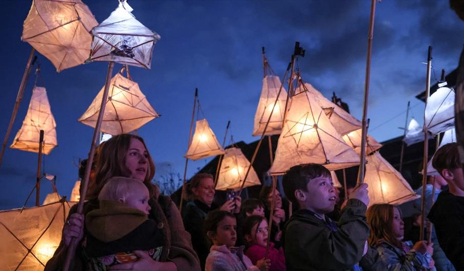 image of children and adults holding paper lanterns on sticks
