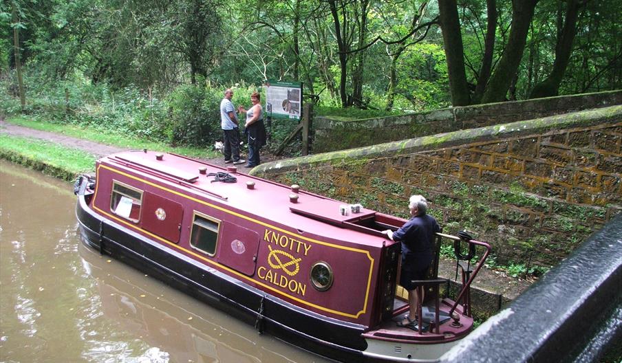 A narrow boat on the Caldon Canal passes below Turnover Bridge