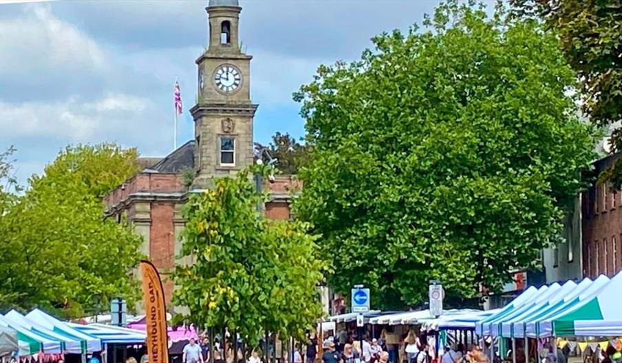 A street with outdoor stalls and a church in the background