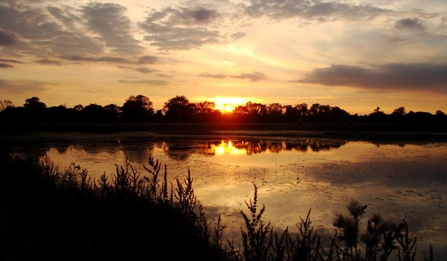 Image shows a beautiful sunset over water at Middleton Lakes