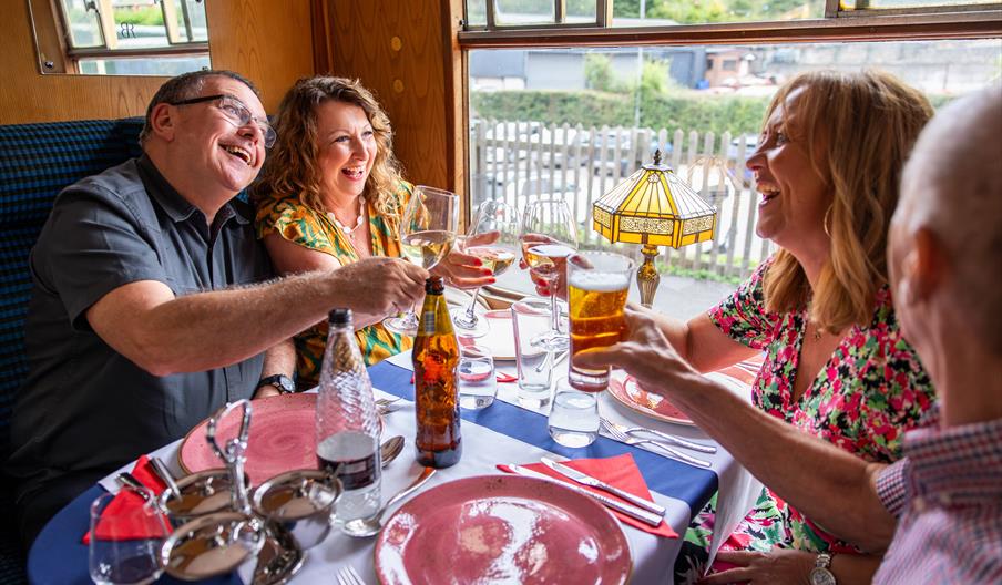 Two couples enjoy a curry aboard a steam train