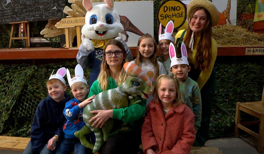 Image shows a group of children and staff from Lower Drayton Farm, including an Easter bunny and a baby dinosaur!
