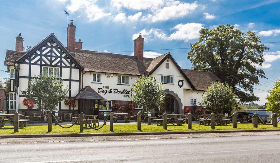 Image shows the front of The Dog & Doublet Inn, taken on a sunny day