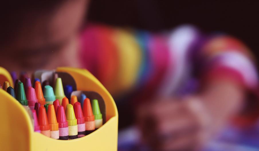 Yellow box of colourful crayons