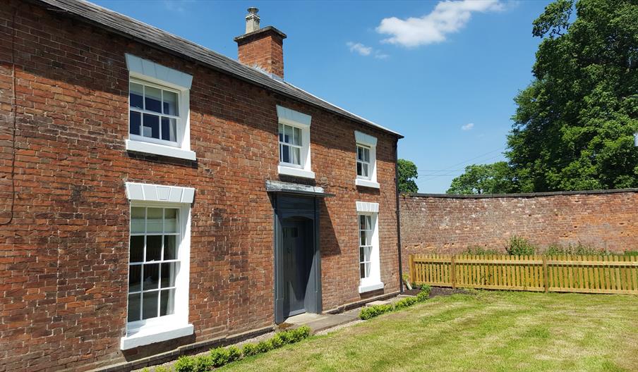 Photo shows the front of the Gardners Cottage on a sunny day