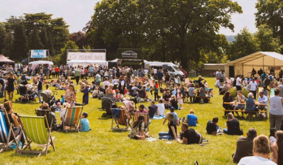 A host of great food stalls, with visitors relaxing in the sunshine, at The Trentham Estate, Staffordshire