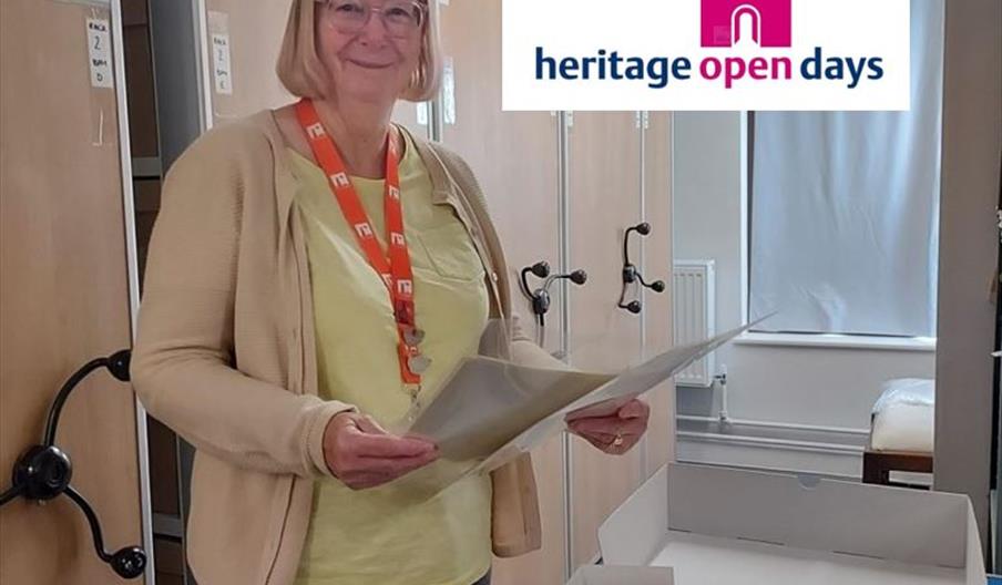 A woman stands outside Middleport Pottery's archives, with some old documents in her hands