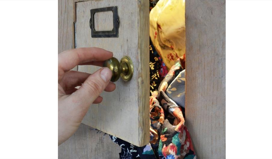 image of a door opening with textiles falling out