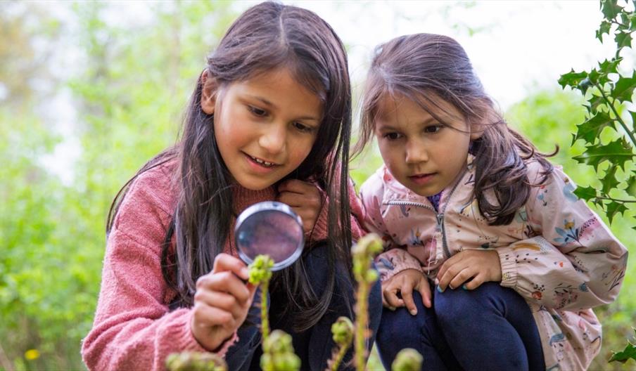 image of 2 girls with a magnifying glass