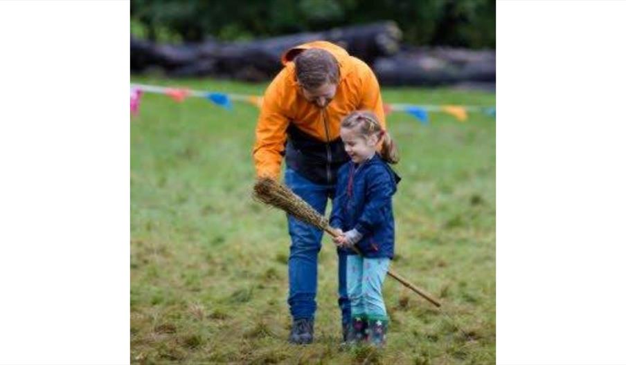 image of an adult male and female child with a broom