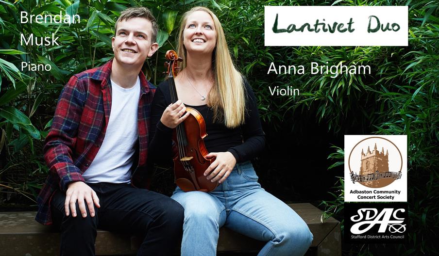 Image shows the two members of the Lantivet Duo, Brendan Musk and Anna Brigham, sitting on a bench in a garden. Anna is holding a violin.