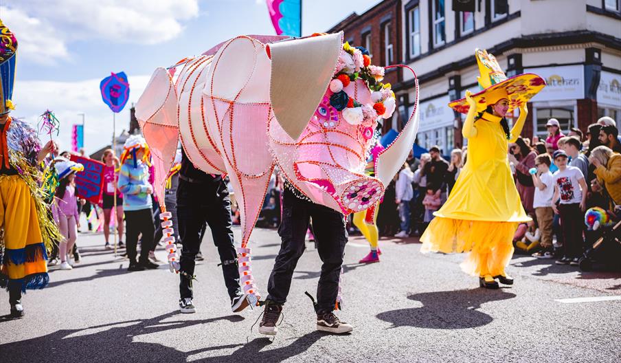 Image shows a colourful parade on a sunny day