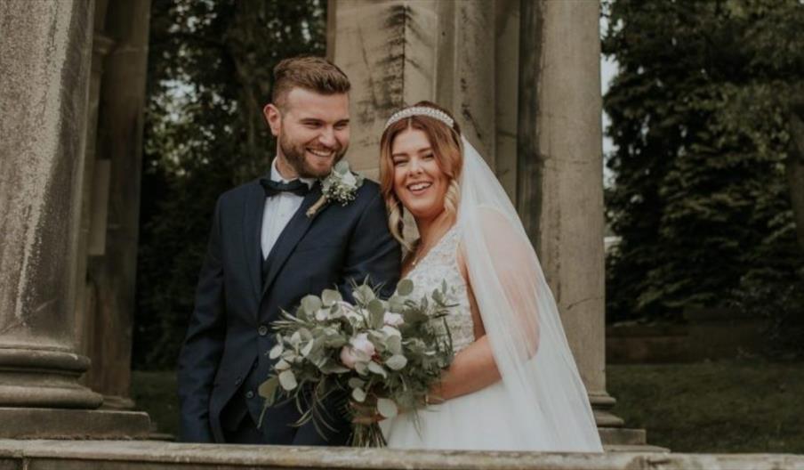 A bride and groom under an archway at The Trentham Estate