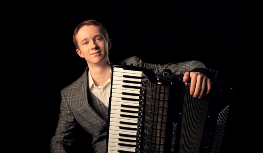 Image shows a musician with his accordion