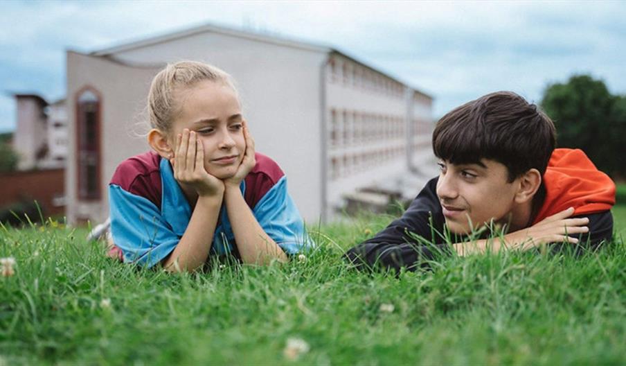 image of a girl and boy lying on grass