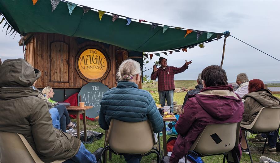 image shows Ian Douglas story telling to an outdoor audience