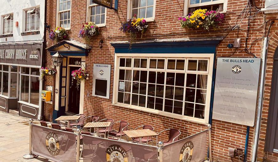 The frontage of The Bulls Head, Stoke-on-Trent, on a sunny day, with chairs and tables outside