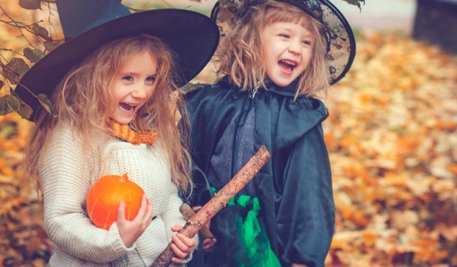 Two young witches with their pumpkins and broomsticks at Tittesworth Water, Staffordshire