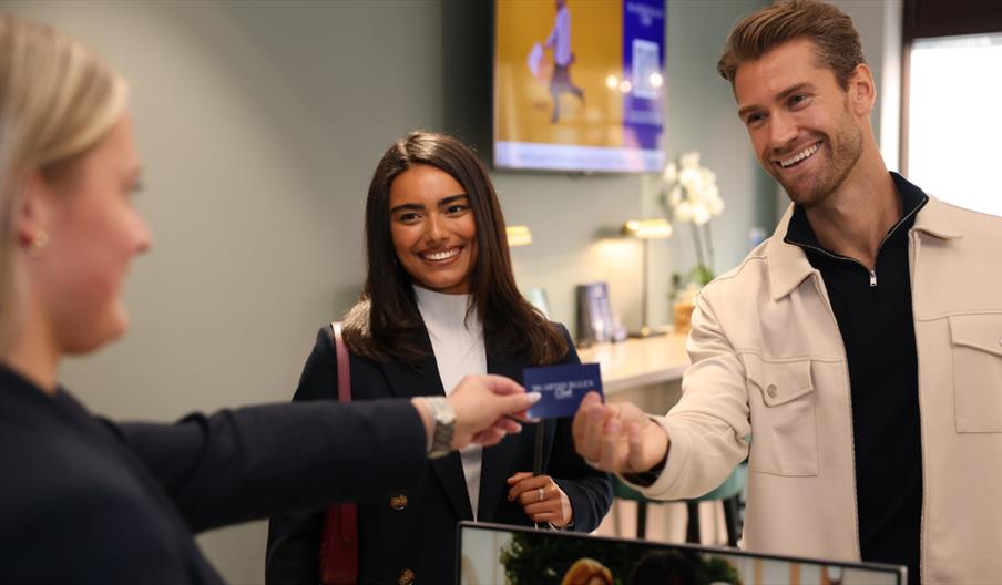 Customer receiving a loyalty card during an in‑store shopping experience