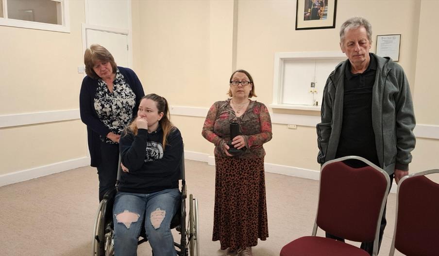 Girl on wheelchair surrounded by two women and a man