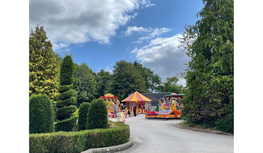 Mini vintage fun fair set among trees at Byrkley Park Garden Centre.