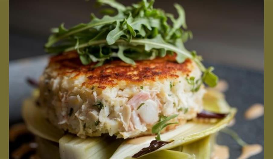 Golden pan-fried crab cake topped with fresh rocket.