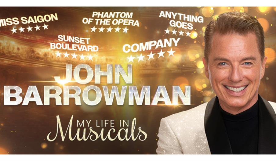 Promotional poster with gold stage‑light background featuring a smiling performer in a white jacket, with large text reading “John Barrowman – My Lif