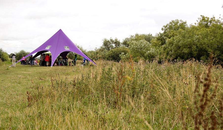 Photo showing a big event tent in a field