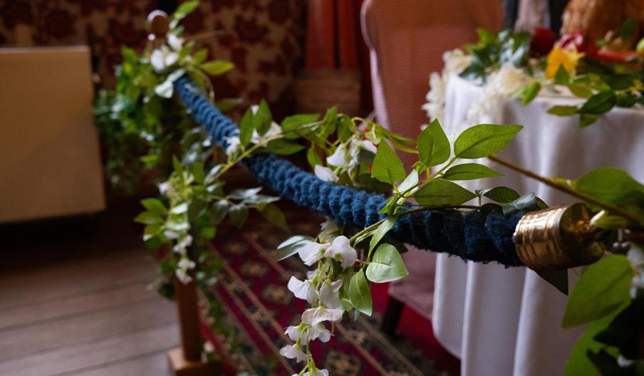 Image shows a rope barrier, with flowers attached