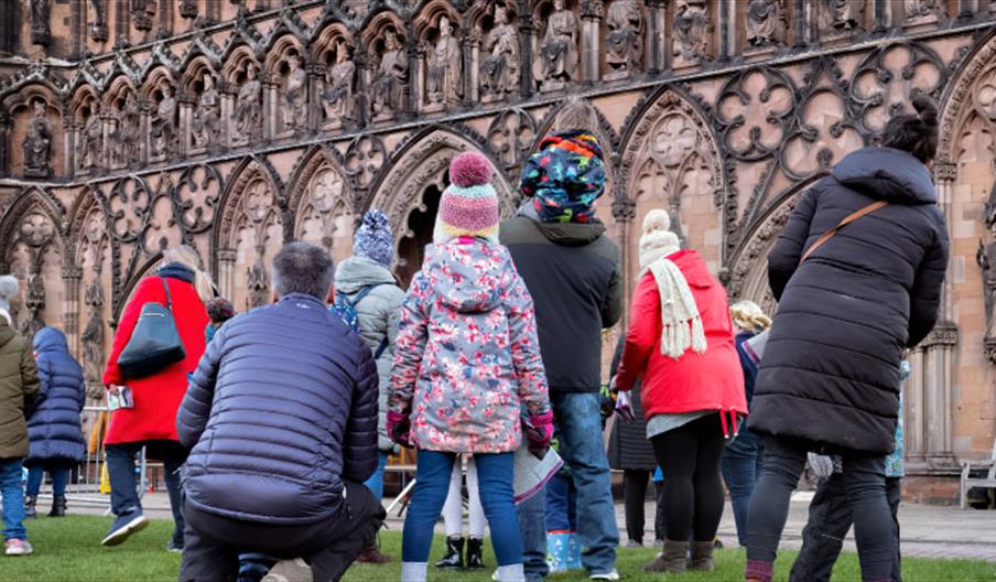 Image shows families gathering outside Lichfield Cathedral on a chilly day
