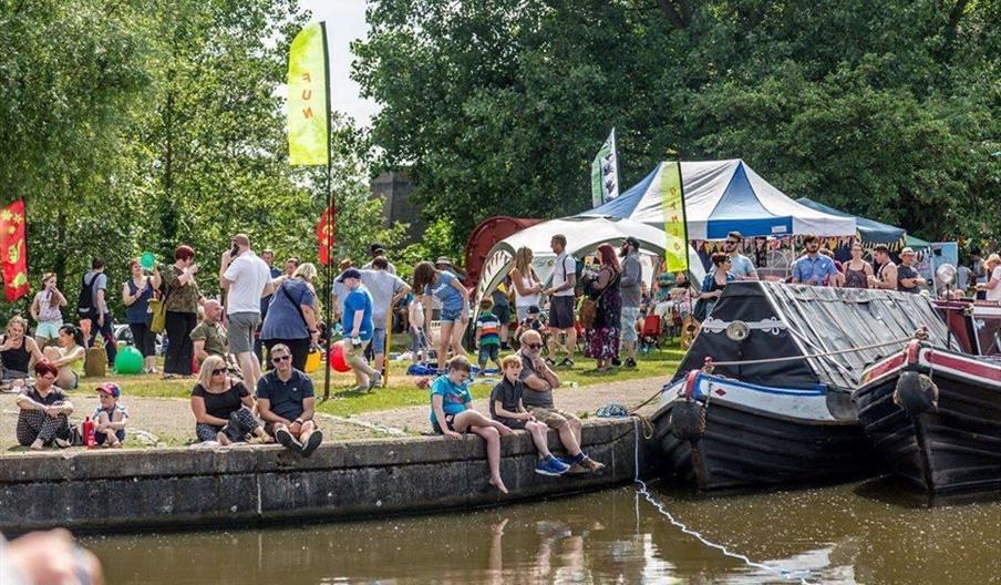 Image of people sitting on the edge of a canal.
