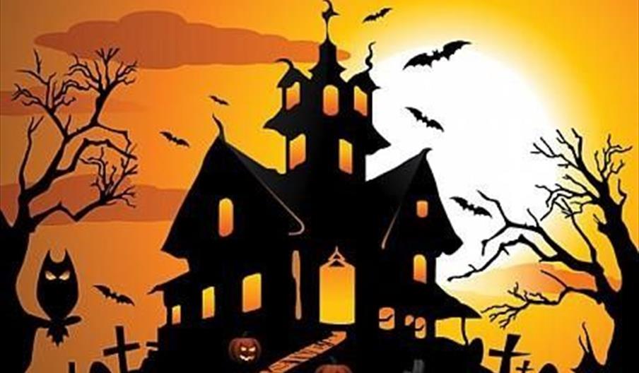 A cartoon haunted house at sunset, with bats, gravestones, and spooky trees, all in silhouette