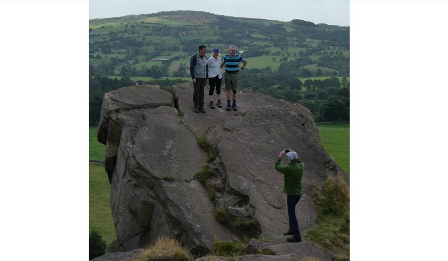 image of walkers standing on a rock